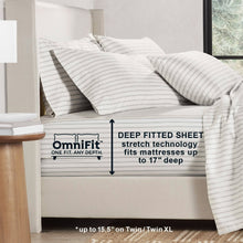 White sheet set with thin gray stripe print, draped on the mattress with pillowcases