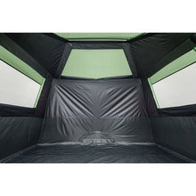 Cabin tent interior with black fabric walls and green trim, tunnel-style doorway
