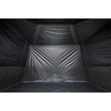 Cabin tent interior showing dark walls, ceiling panels, and central floor opening