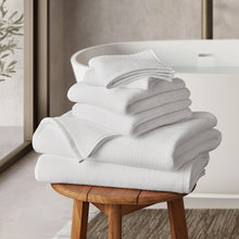 Spa towel set in arctic white, neatly folded stack with textured dobby weave