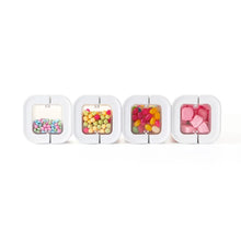 Four small clear flip-lock containers with lids, filled with pastel and pink candies