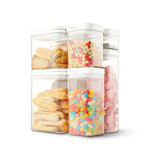 Stacked clear flip-lock pantry containers with colorful candy and snacks inside