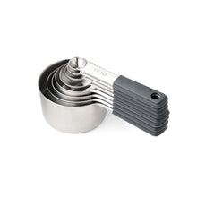 Stacked stainless steel measuring cups with black measuring handle
