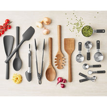 Stainless steel measuring cups and spoons set with dark grips, assorted tools