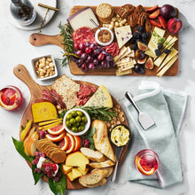 Acacia wood charcuterie boards set of 2 with handles, one round and one paddle shape.