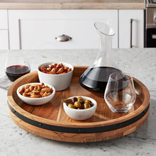 Acacia wood lazy Susan turntable with black rim, serving bowls and decanter on top