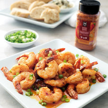Bang Bang seasoning bottle next to a plate of shrimp with green onion garnish