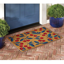 Coir doormat with cherry and leaf design, tan surface with red and blue foliage