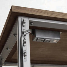 Desk underside with metal bracket hardware and support rail under dark brown top
