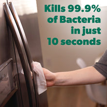 Hand holding disinfecting wipe for cleaning a bathroom surface