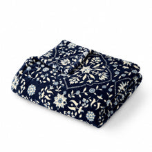 Indigo blue folded throw with white floral and vine pattern