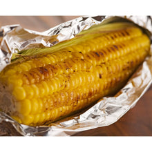 Corn on the cob wrapped in crinkled aluminum foil