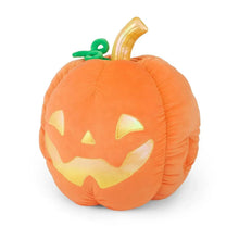 Orange jack-o-lantern plush stuffed animal with green stem and carved smile.