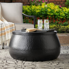 Round black hammered metal coffee table with storage, tabletop open with serving tray
