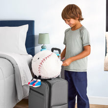 Gray suitcase with a white plush baseball ball with red stitching, held by a child