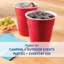 Two red disposable plastic party cups with ice on a table