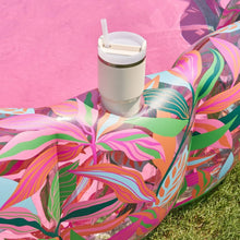 Inflatable lounge pool with multicolor tropical leaf print and attached cup holder