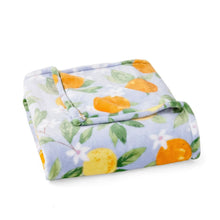 Lounge throw blanket folded, white with orange lemons and green leaves