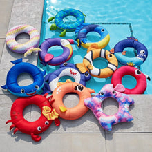 Assorted animal mesh ring floats arranged on a pool deck with colored ring centers