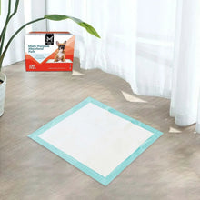 Teal-bordered absorbent pad on floor with product box in background