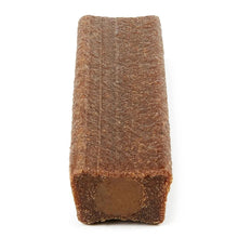 Brown dog chew bone piece standing upright with dark end cutout