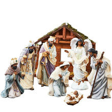 Nativity set scene with wooden stable, multiple dressed figures, and baby in manger