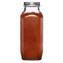 Glass jar of ground cayenne pepper with metal lid, label not shown