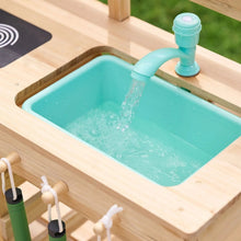 Wooden mud kitchen sink basin with turquoise water and faucet