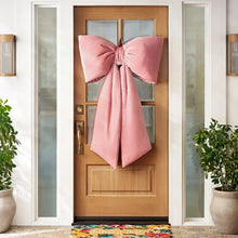 Oversized velvet bow decor with wide pink loops and long trailing tails