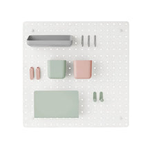 White pegboard organizer board with pastel bins and tool holders