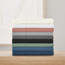 Assorted solid sheet set stack in white, coral, gray, black, green, and blue