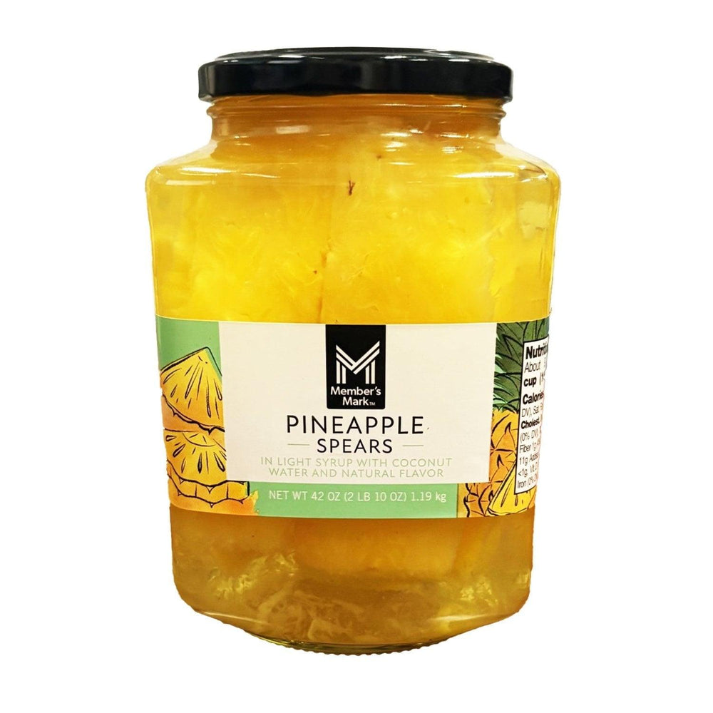 Jar of pineapple spears in coconut water, black lid, yellow pineapple pieces