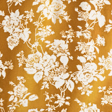 Close-up plush blanket fabric with white floral vines on orange background