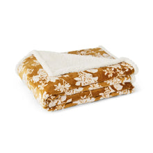 Folded plush blanket with orange floral print and white plush border