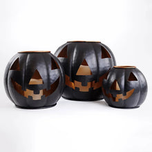 Set of 3 black metal jack-o-lantern lanterns with carved orange faces and bronze rims