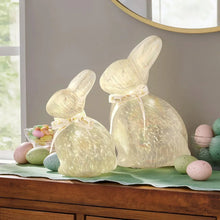 Pre-lit glass bunny décor set of 2 with pale glowing finish and tied ribbon bows