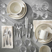 Stainless steel flatware assortment with forks, spoons, knives and cups