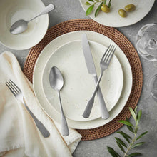 Stainless steel fork, knife, and spoon set on white plates