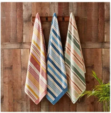 Striped beach towels hanging, blue and green with coral and yellow accents, vertical stripes