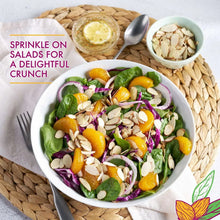 Salad bowl topped with sliced almonds and leafy greens