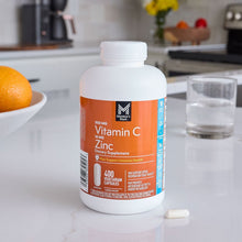 Vitamin C and Zinc dietary supplement bottle with capsules on a table