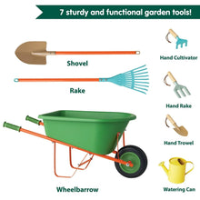 Green wheelbarrow with shovel, rake, hand tools, and yellow watering can