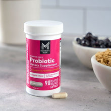 Probiotic dietary supplement bottle with one capsule on a countertop