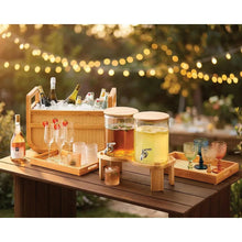 Woven drink cooler with wooden base, side shelves, and two tap beverage dispensers