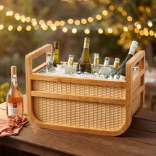 Woven drink cooler with light wood frame and wicker front panels, open top handle bars