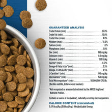 Dry dog food kibble pellets in metal bowl, close-up