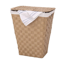 Handwoven laundry hamper with white liner and folded white towel on top, light tan woven body