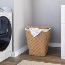 Woven laundry hamper with white liner and folded cloth on top, natural tan.