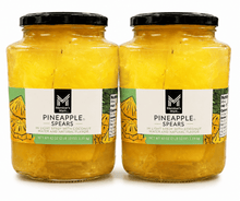 Two jars of pineapple spears in coconut water, black lids, yellow contents
