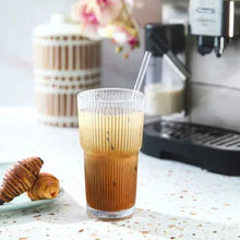 Ribbed glass cup with straw, amber drink with vertical fluted texture